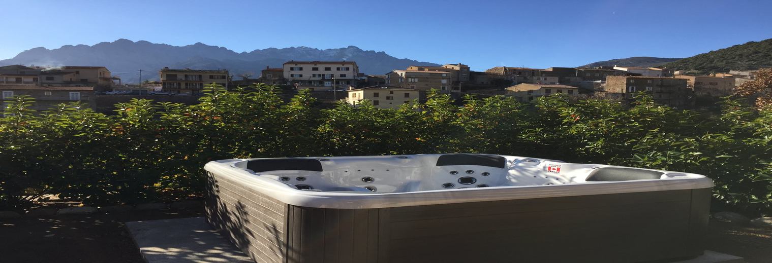 Spa installé sur une terrasse avec vue sur un village et les montagnes corses